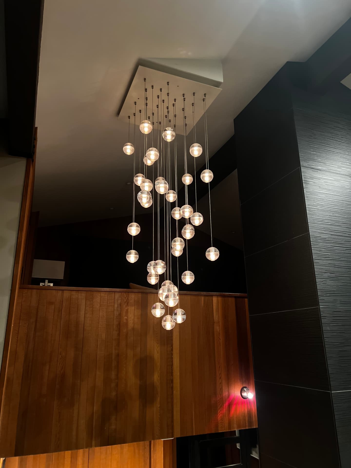 Cascading glass globe pendants in a two-story entry