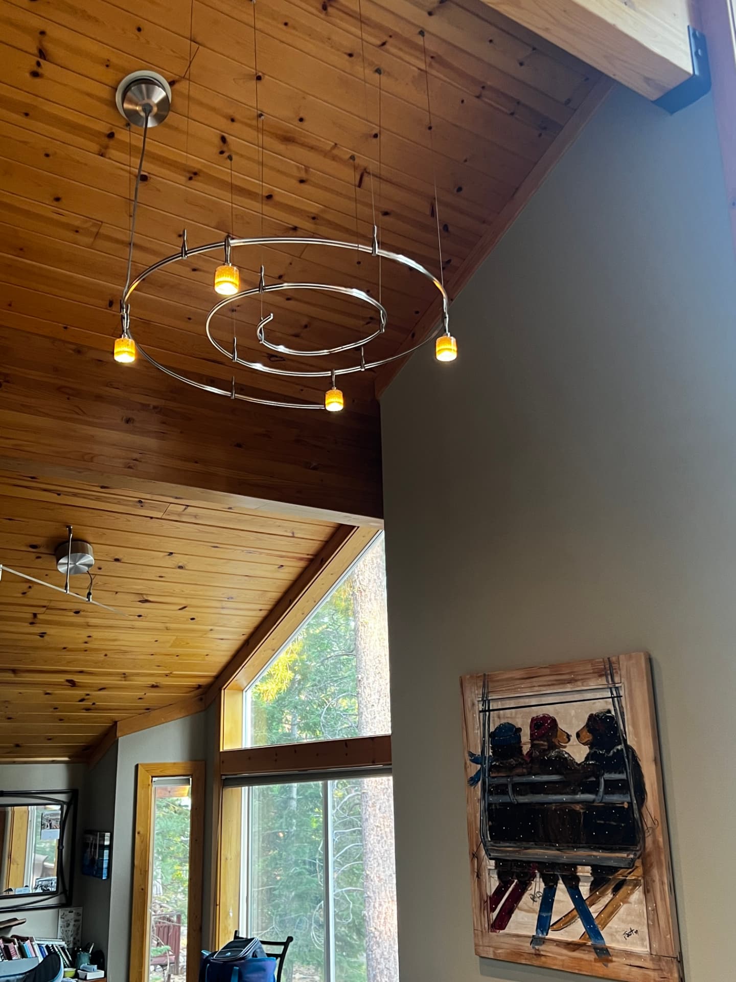 Suspended circular track lighting on a knotty pine vaulted ceiling
